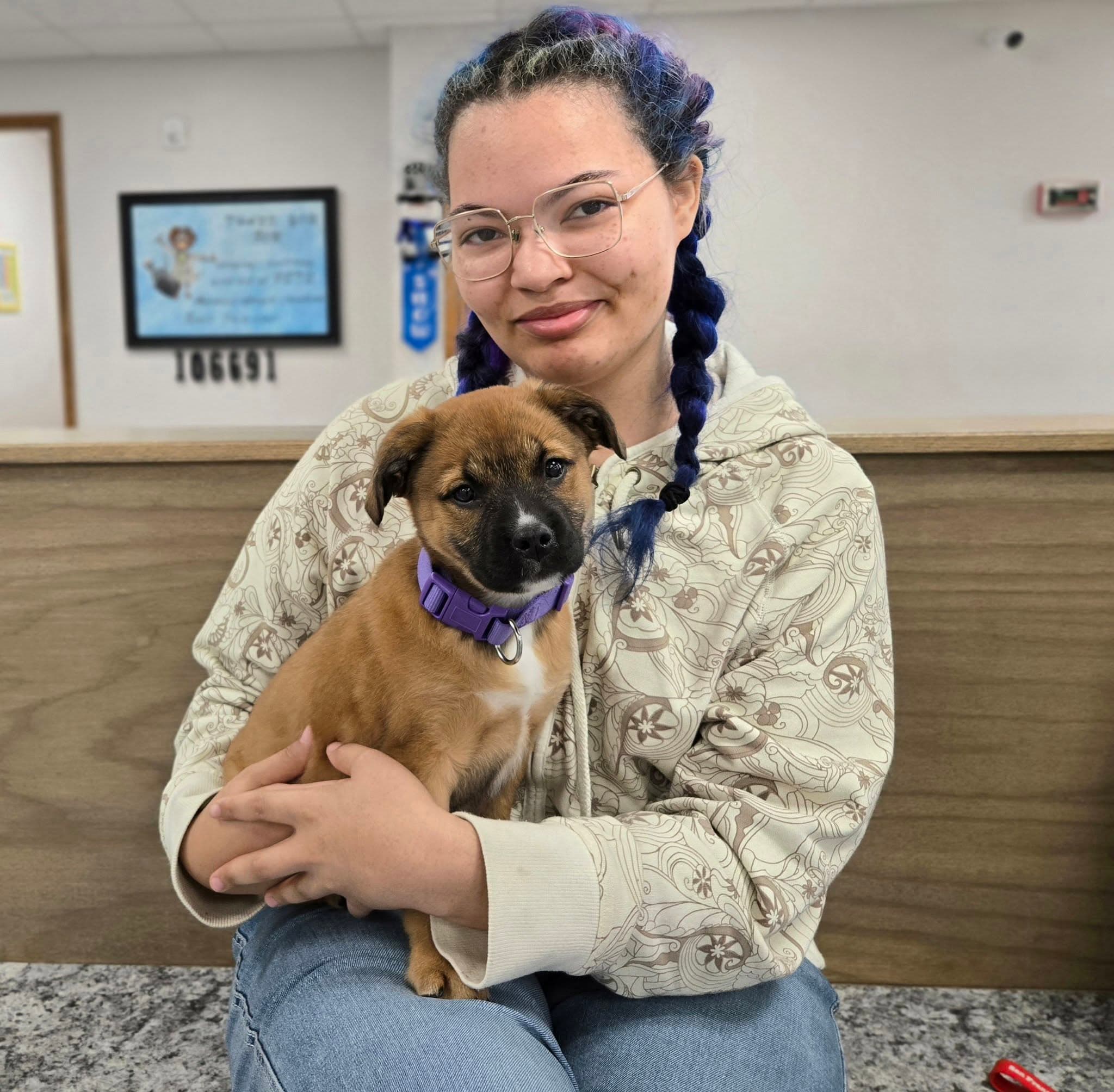 A PETS Clinic client holding a puppy at the clinic