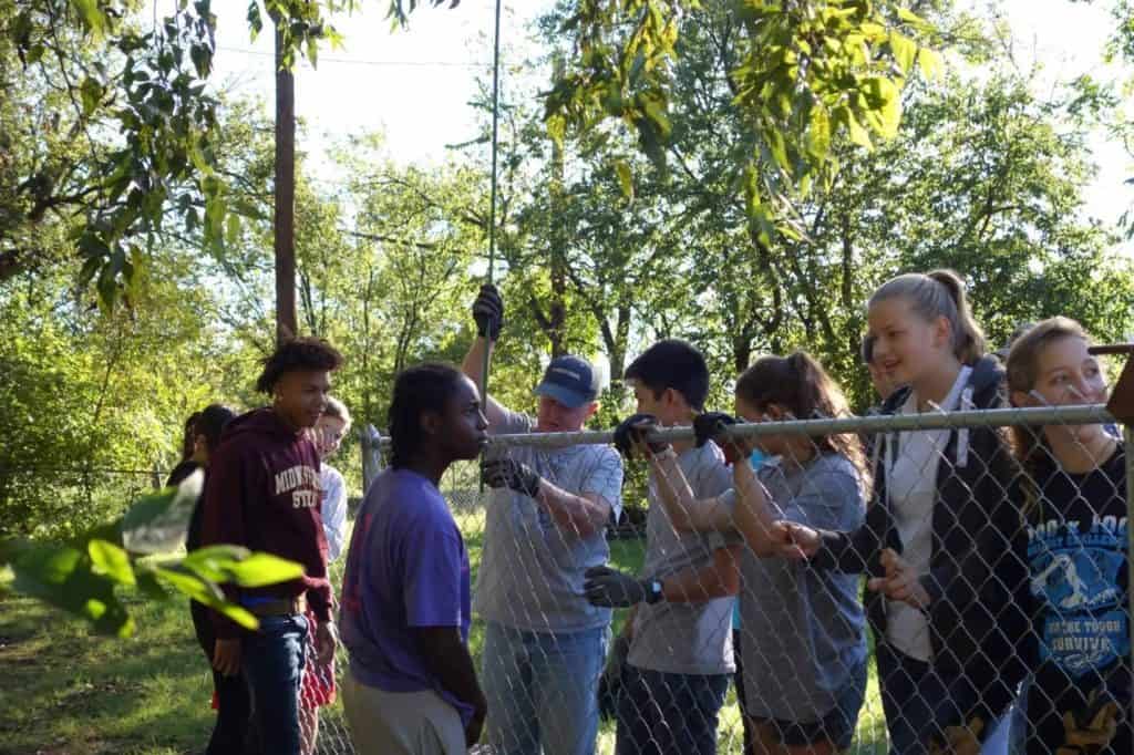 PETS Clinic Chain-Off volunteers building a fence for a local dog